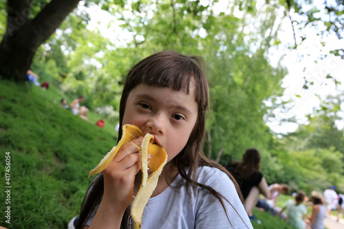 Young girl eating banana in the park