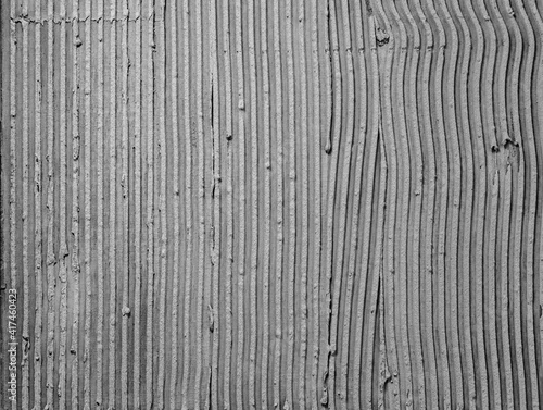 Texture applied tile adhesive on wall, ribbed concrete background close-up.