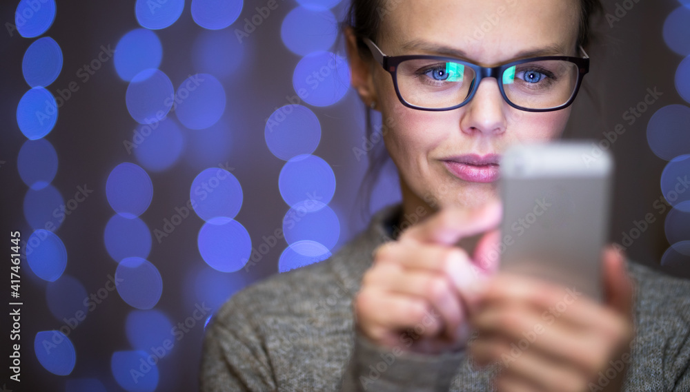 Young woman using her cell phone at home Young woman using her cell phone at home