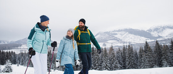 Family with small daughter on a walk outdoors in winter nature, Tatra mountains Slovakia.