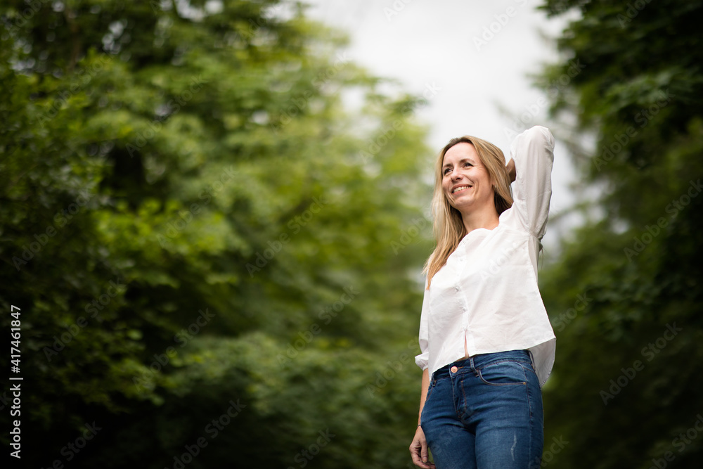 Portrait of a relaxed middle aged woman outdoors, looking happy, enjoying the life Portrait of a relaxed middle aged woman outdoors, looking happy, enjoying the life