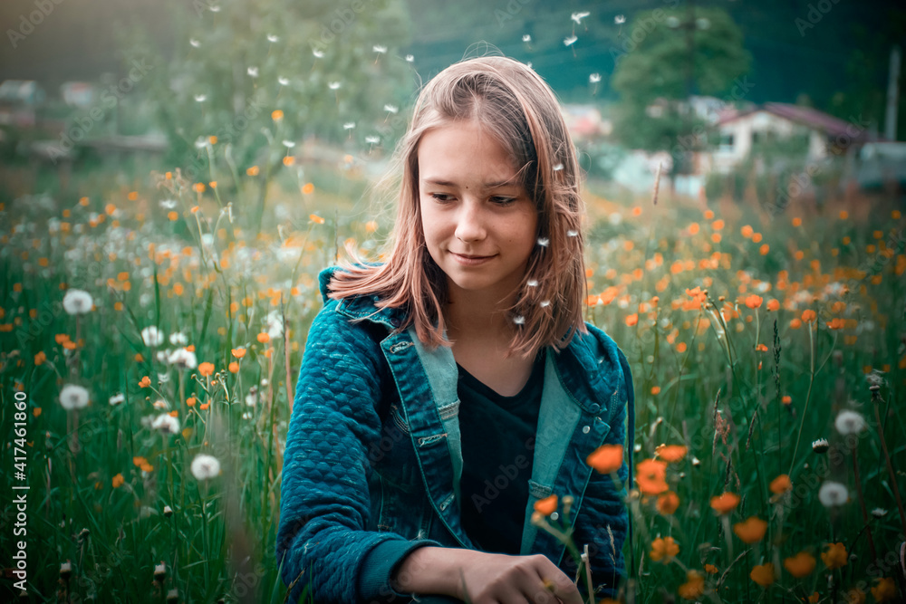 young girl picks flowers in a summer meadow young girl picks flowers in a summer meadow