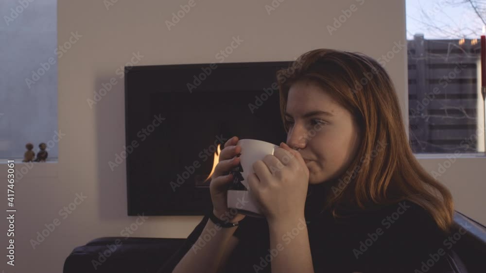 Teenage Girl Relaxing By Fire And Drinking Teenage Girl Relaxing By Fire And Drinking