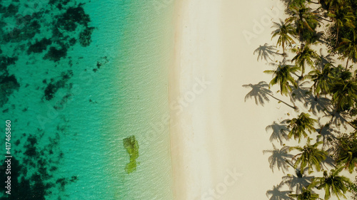 Coast with sandy beach with tourists and clear blue sea top view, Puka shell beach. Boracay, Philippines. Seascape with beach on tropical island. Summer and travel vacation concept.