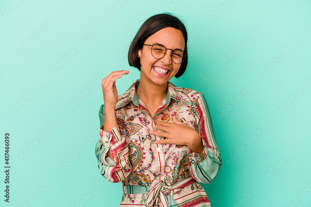 Young mixed race woman isolated on blue background laughing about something, covering mouth with hands. Young mixed race woman isolated on blue background laughing about something, covering mouth with hands.