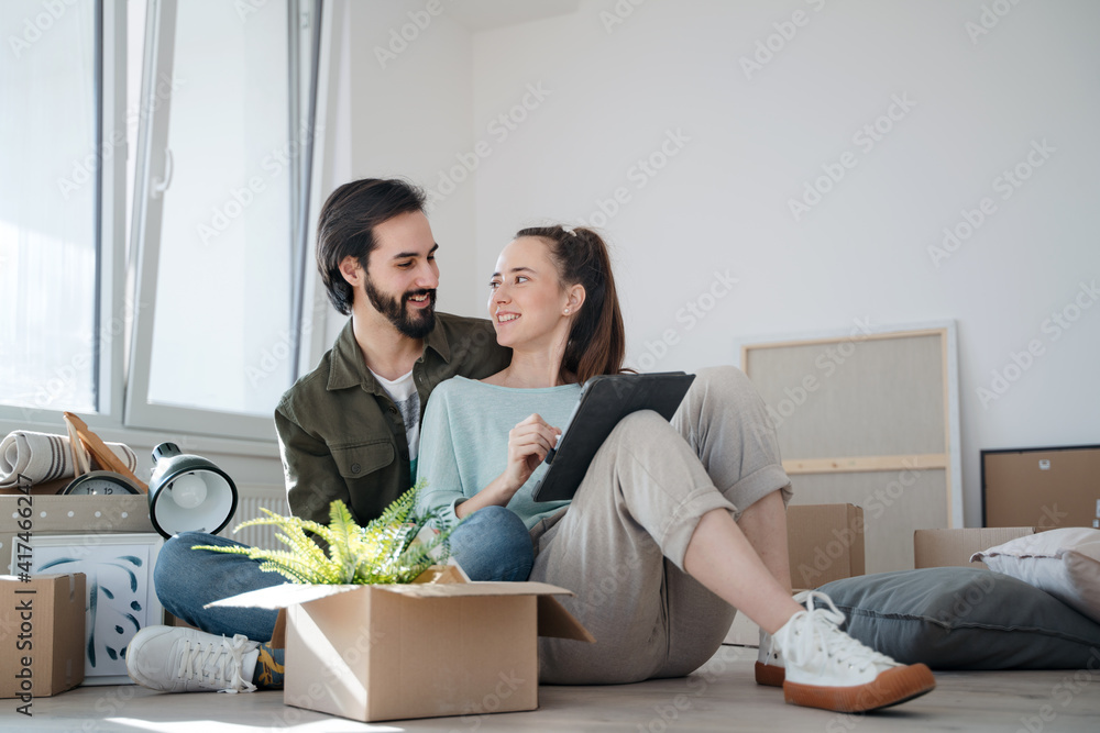 Young couple with boxes moving in new flat, new home and relocation concept. Young couple with boxes moving in new flat, new home and relocation concept.