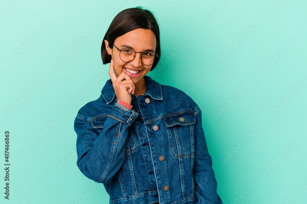 Young mixed race woman isolated on blue background smiling happy and confident, touching chin with hand. Young mixed race woman isolated on blue background smiling happy and confident, touching chin with hand.