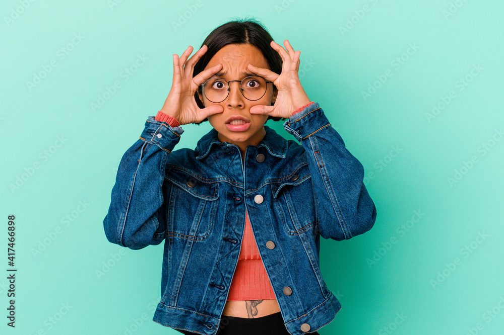 Young mixed race woman isolated on blue background keeping eyes opened to find a success opportunity. Young mixed race woman isolated on blue background keeping eyes opened to find a success opportunity.