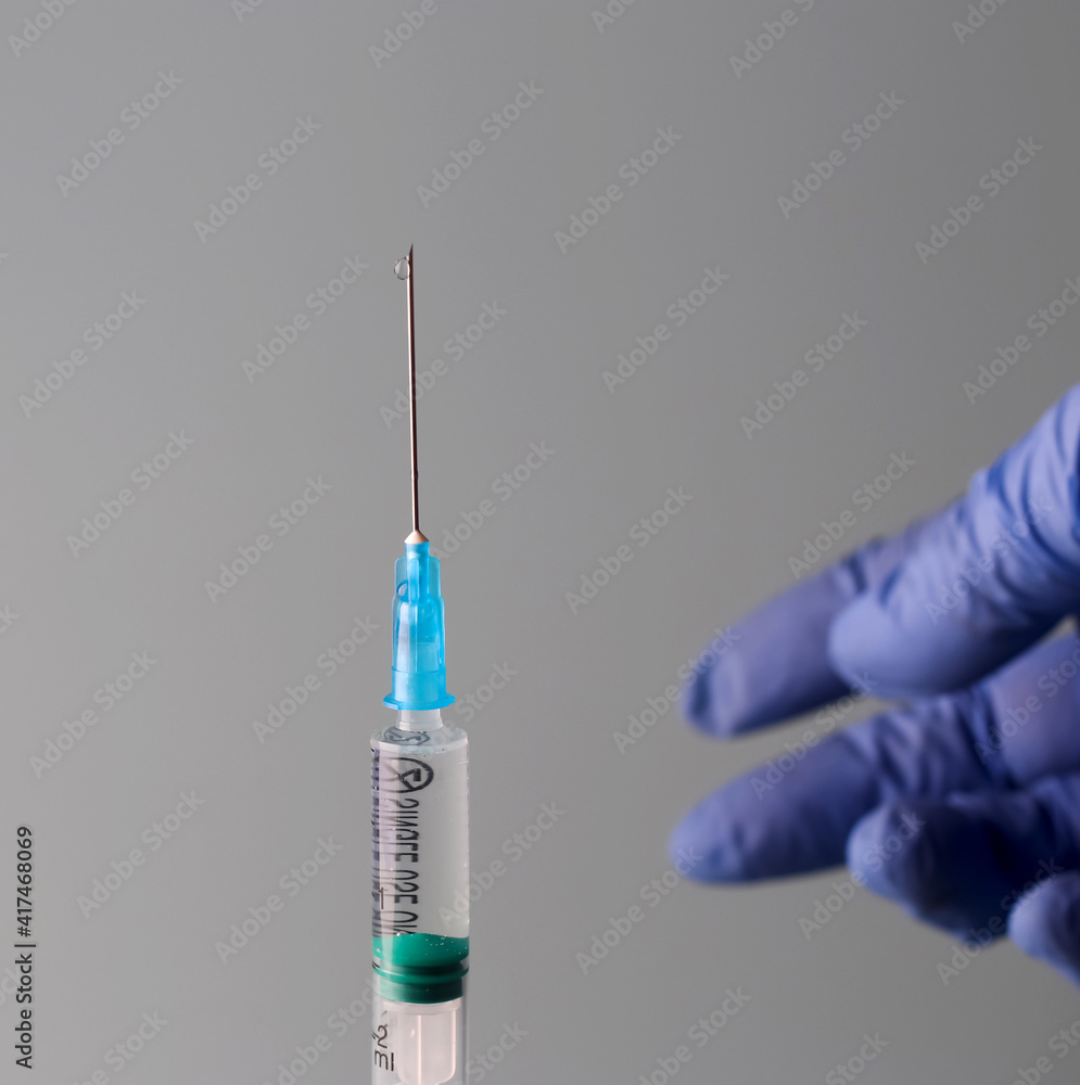 Doctor's hands are holding a syringe filled with vaccine. Prevention, immunization and treatment for coronavirus infection COVID-19, nCoV 2019. COVID19 vaccine concept Doctor's hands are holding a syringe filled with vaccine. Prevention, immunization and treatment for coronavirus infection COVID-19, nCoV 2019. COVID19 vaccine concept