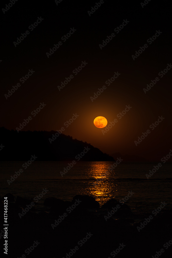 An orange full moon over the Black sea at the South coast of Crimea