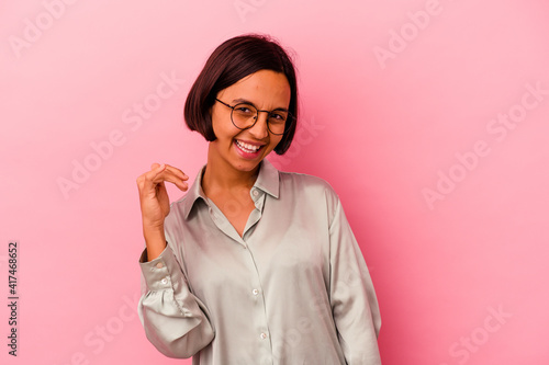 Young mixed race woman isolated on pink background laughing about something, covering mouth with hands.