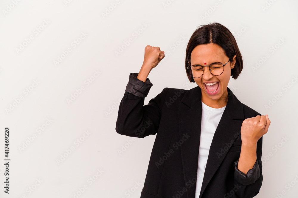 Young business Indian woman isolated on white background raising fist after a victory, winner concept. Young business Indian woman isolated on white background raising fist after a victory, winner concept.