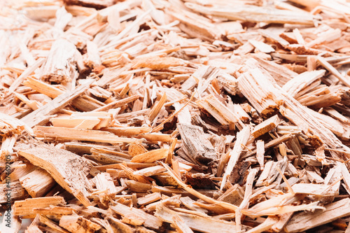 Small pile of wood chips close up background. Waste from the woodworking industry, fuel and raw materials for heating solid fuel industrial boilers on wood chips
