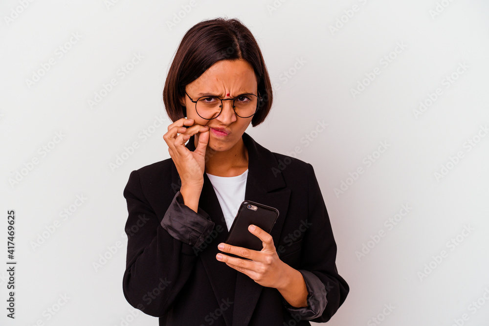 Young indian business woman holding a phone isolated Young business indian woman holding a phone isolated with fingers on lips keeping a secret. Young indian business woman holding a phone isolated Young business indian woman holding a phone isolated with fingers on lips keeping a secret.