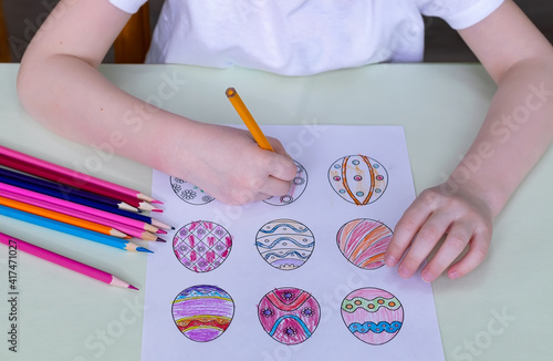 Children's hands draw Easter eggs. Preparation for the holiday. Concept: religious holidays. Concept: early childhood education.
