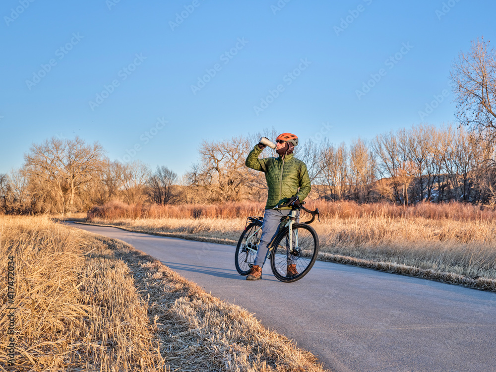hydration break during winter or fall commuting on a bike trail - Poudre River Trail in northern Colorado hydration break during winter or fall commuting on a bike trail - Poudre River Trail in northern Colorado
