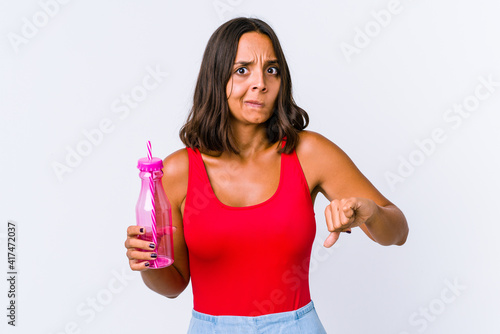 Young mixed race woman holding a milk shake isolated showing thumbs up and thumbs down, difficult choose concept