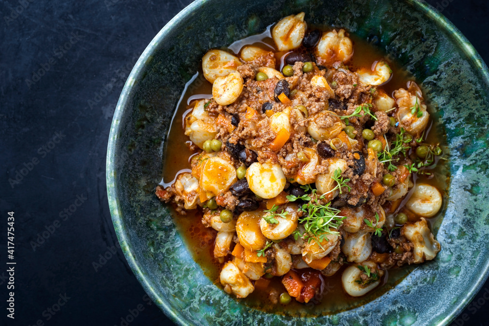 Foto de Modern style traditional slow cooked Mexican pozole rojo soup with ground minced beef