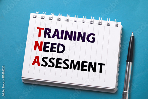 Training Need Assesment, text words typography written on paper against on blue background, life and business motivational inspirational photo