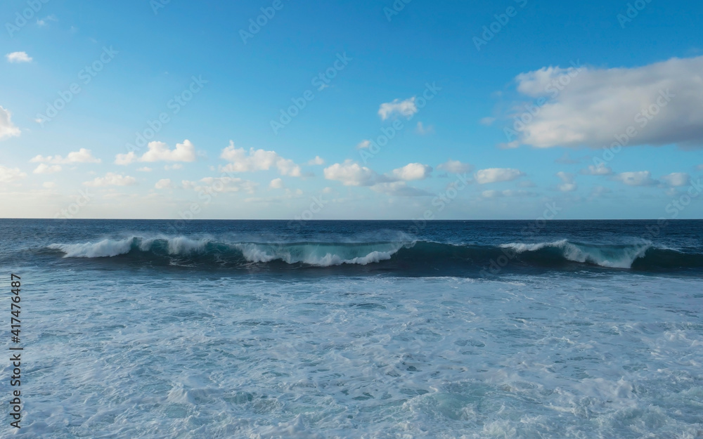 Big breaking waves splash with foam and blue sky, white clouds at atlantic ocean, Gran Canaria, Canary Islands of Spain
