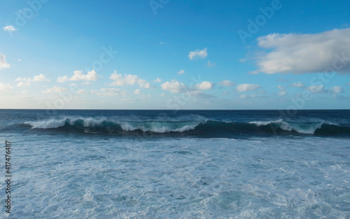 Big breaking waves splash with foam and blue sky  white clouds at atlantic ocean  Gran Canaria  Canary Islands of Spain