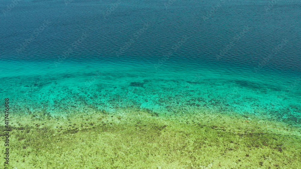 Blue background with transparent sea water copy space for text. Sea water surface in lagoon and coral reef. Top view transparent turquoise ocean water surface. background texture