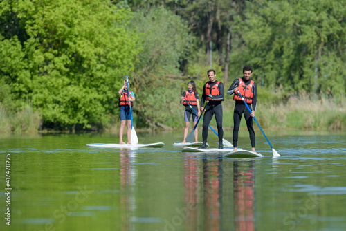 Bild auf Leinwand stand up paddle group on a lake