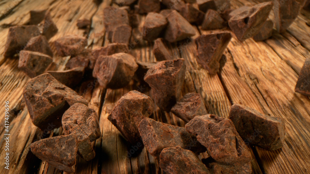 Rolling pieces of chocolate placed on wooden planks Rolling pieces of chocolate placed on wooden planks
