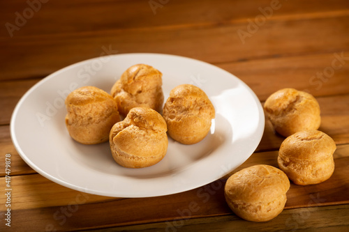 Delicious profiteroles on the table. Profiteroles dessert. Image with selective focus.