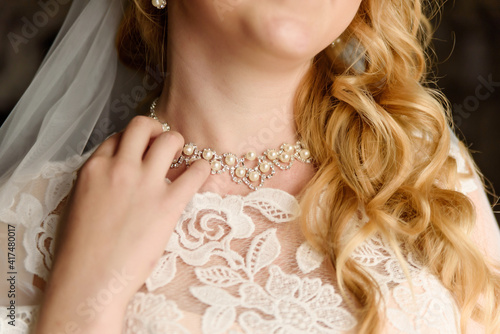 The bride adjusts her necklace