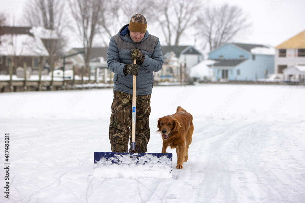 man and a dog shoveling snow
