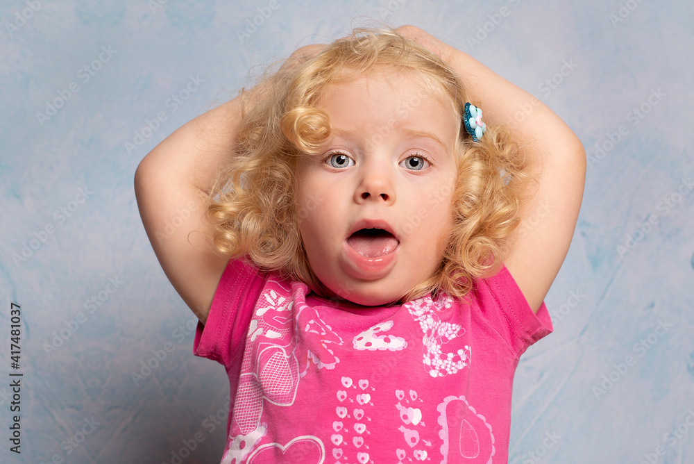 Naklejka premium Portrait of a cute little curly blonde 2 year old girl