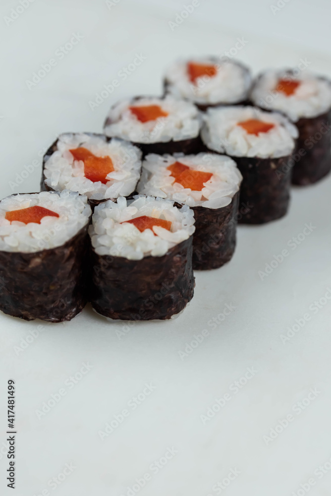 Sushi rolls prepared by professional asian chef with traditional Japanese ingredients. Salmon, rice, vegetables, sesame seeds. Sushi rolls prepared by professional asian chef with traditional Japanese ingredients. Salmon, rice, vegetables, sesame seeds.