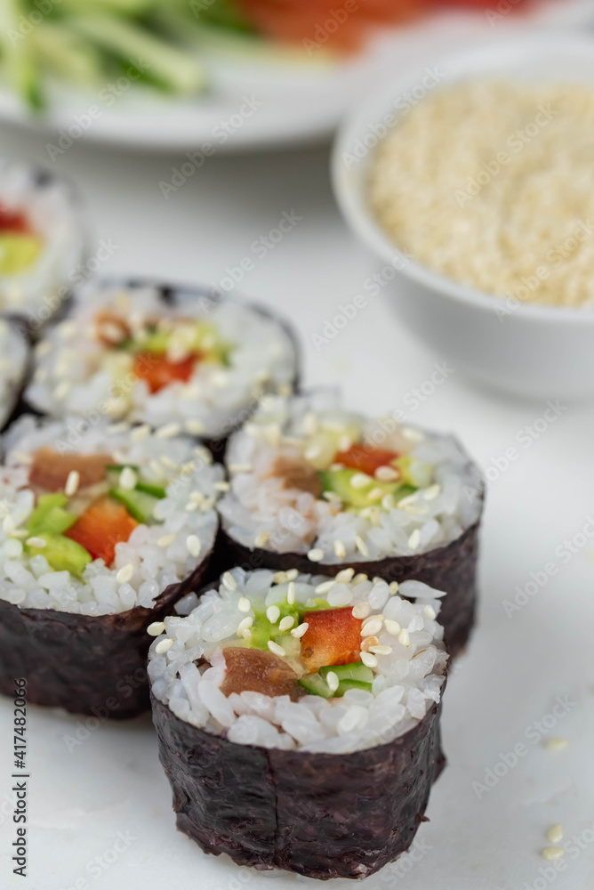 Sushi rolls prepared by professional asian chef with traditional Japanese ingredients. Salmon, rice, vegetables, sesame seeds. Sushi cooking and making concept Sushi rolls prepared by professional asian chef with traditional Japanese ingredients. Salmon, rice, vegetables, sesame seeds. Sushi cooking and making concept
