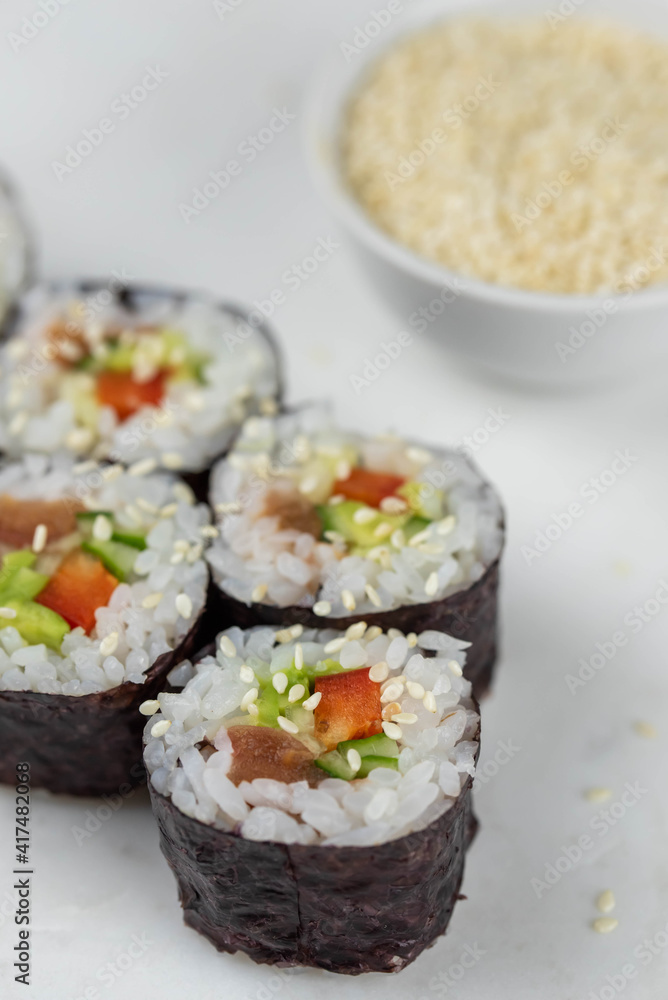 Sushi rolls prepared by professional asian chef with traditional Japanese ingredients. Salmon, rice, vegetables, sesame seeds. Sushi cooking and making concept Sushi rolls prepared by professional asian chef with traditional Japanese ingredients. Salmon, rice, vegetables, sesame seeds. Sushi cooking and making concept