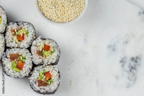 Sushi rolls prepared by professional asian chef with traditional Japanese ingredients. Salmon, rice, vegetables, sesame seeds. 