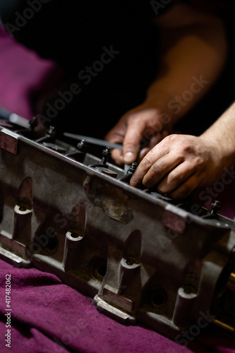 blurred image, male hands adjusting valve clearances on the cylinder head. cylinder head repair