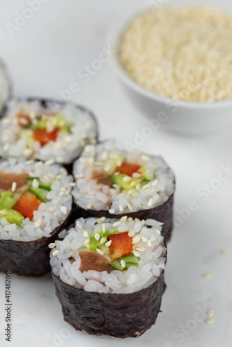 Sushi rolls prepared by professional asian chef with traditional Japanese ingredients. Salmon, rice, vegetables, sesame seeds. Sushi cooking and making concept