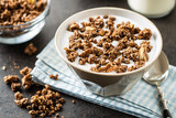 Chocolate breakfast cereal. Morning granola with milk in bowl.