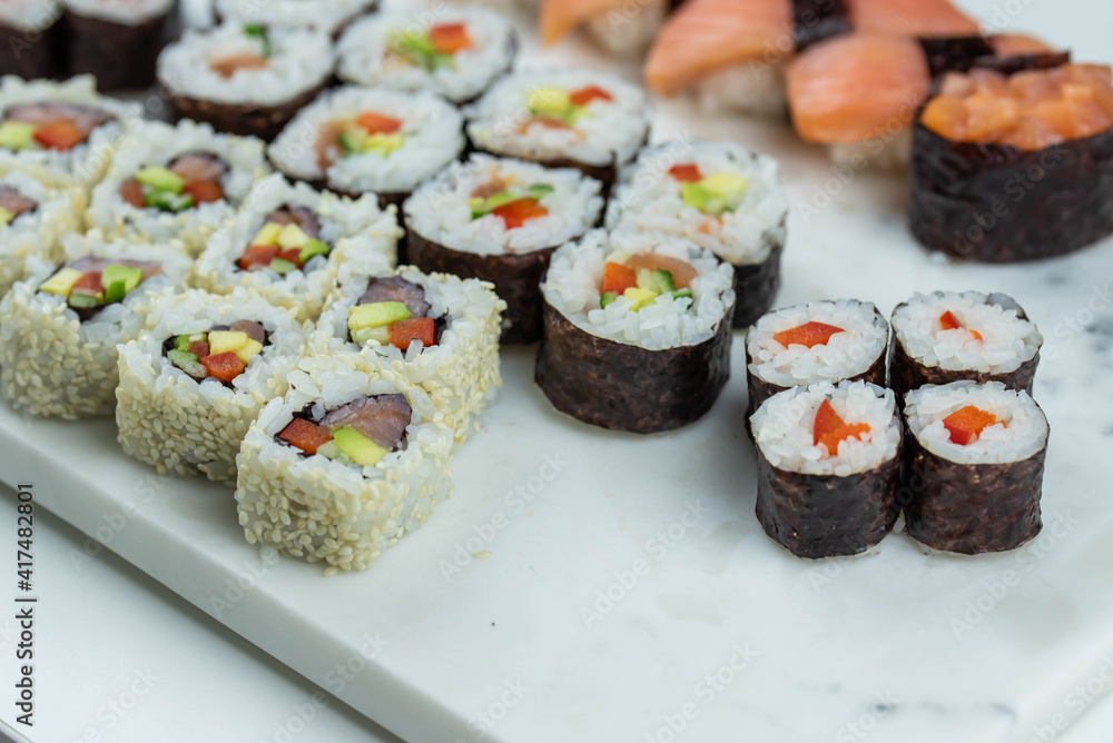 Sushi rolls prepared by professional asian chef with traditional Japanese ingredients. Salmon, rice, vegetables, sesame seeds. Sushi rolls prepared by professional asian chef with traditional Japanese ingredients. Salmon, rice, vegetables, sesame seeds.