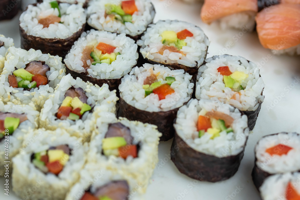 Sushi rolls prepared by professional asian chef with traditional Japanese ingredients. Salmon, rice, vegetables, sesame seeds. Sushi rolls prepared by professional asian chef with traditional Japanese ingredients. Salmon, rice, vegetables, sesame seeds.