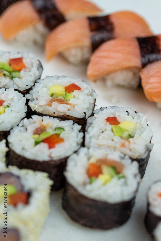 Sushi rolls prepared by professional asian chef with traditional Japanese ingredients. Salmon, rice, vegetables, sesame seeds. Sushi rolls prepared by professional asian chef with traditional Japanese ingredients. Salmon, rice, vegetables, sesame seeds.