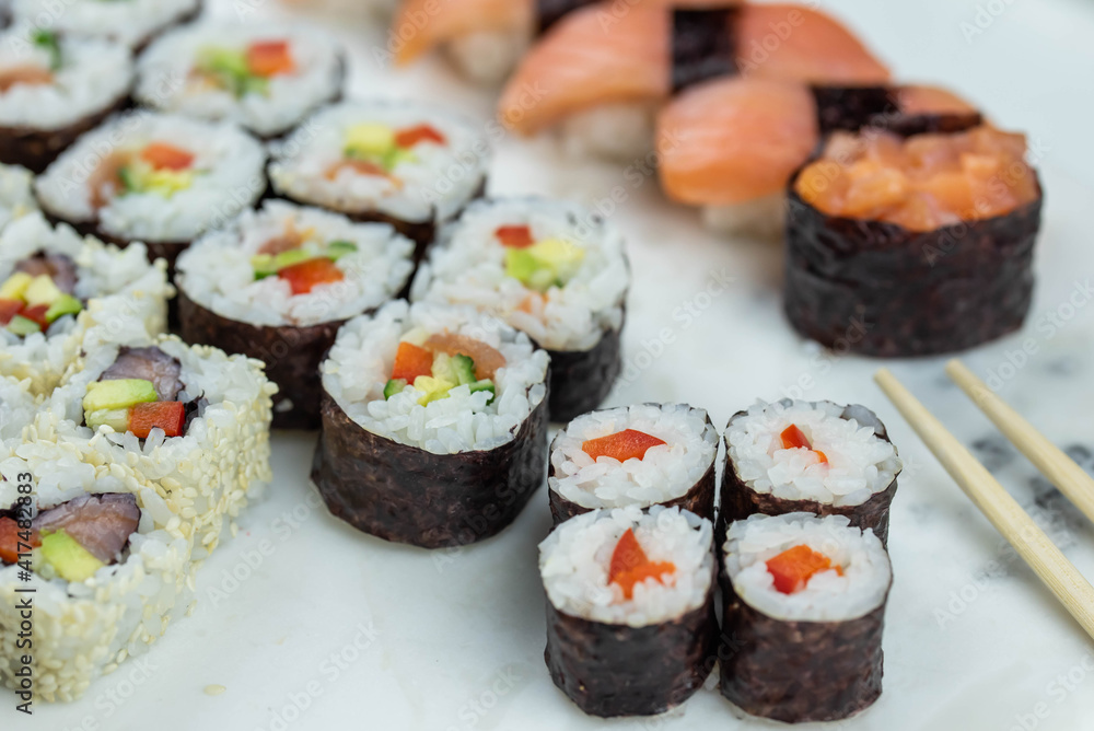 Sushi rolls prepared by professional asian chef with traditional Japanese ingredients. Salmon, rice, vegetables, sesame seeds. Sushi rolls prepared by professional asian chef with traditional Japanese ingredients. Salmon, rice, vegetables, sesame seeds.