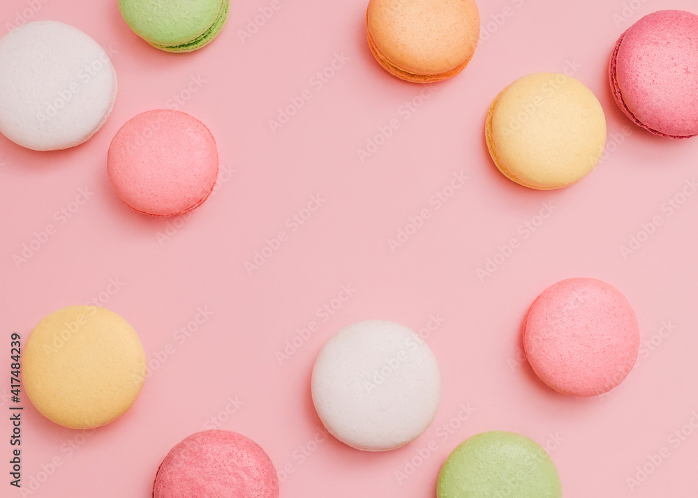 Macaroons Cute top view photo with copy space White, yellow, pink, orange, and green french cookies on pink background Macaroons Cute top view photo with copy space White, yellow, pink, orange, and green french cookies on pink background