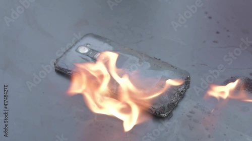 Mobile phone explodes and burns. Cell Phone explosion and fire .Smart Phone Danger from over use or bad manufacturing. Burning up my phone concept.