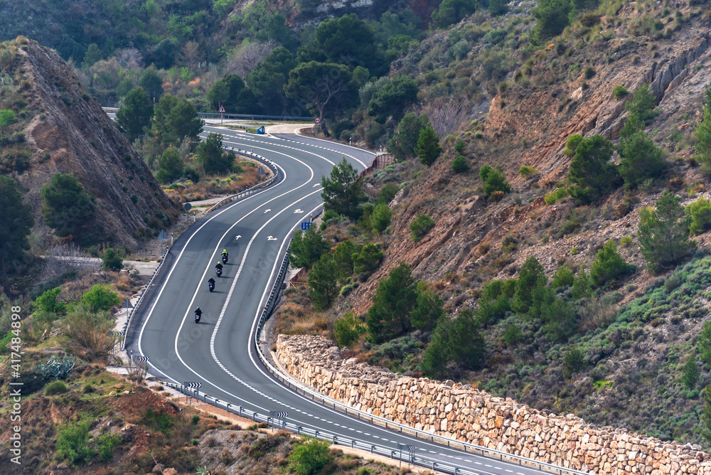 Several riders driving in a row in the middle lane of a conventional road. Several riders driving in a row in the middle lane of a conventional road.