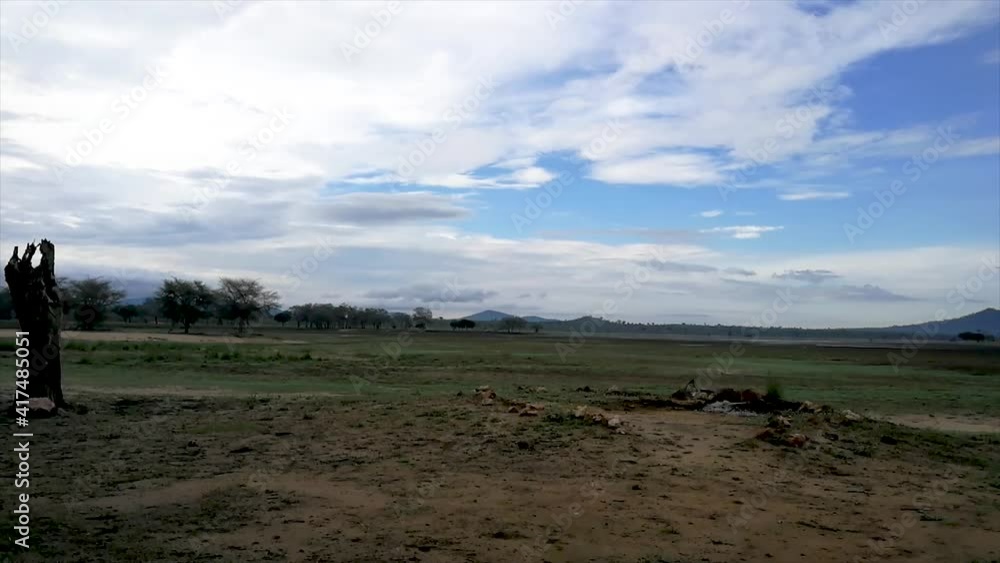 Panning time-lapse of white clouds of the crisp blue sky looking out on a watering hole in Malawi Panning time-lapse of white clouds of the crisp blue sky looking out on a watering hole in Malawi
