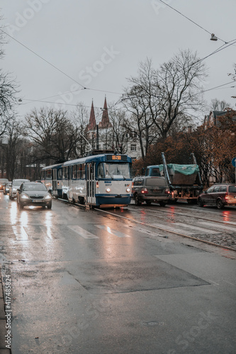 Rainy street of Riga with a Soviet tram and cars.