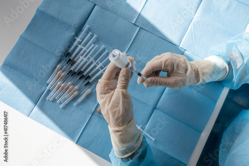 A medical worker prepare an injection of vaccine during a massive vaccination day at a healthcare centre.  Syringes in preparation and ready to use to inoculate the vaccine against the Coronavirus. photo