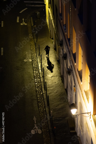 Une homme cours dans une sombre ruelle la nuit, pentes de La Croix-Rousse,  Lyon, France 